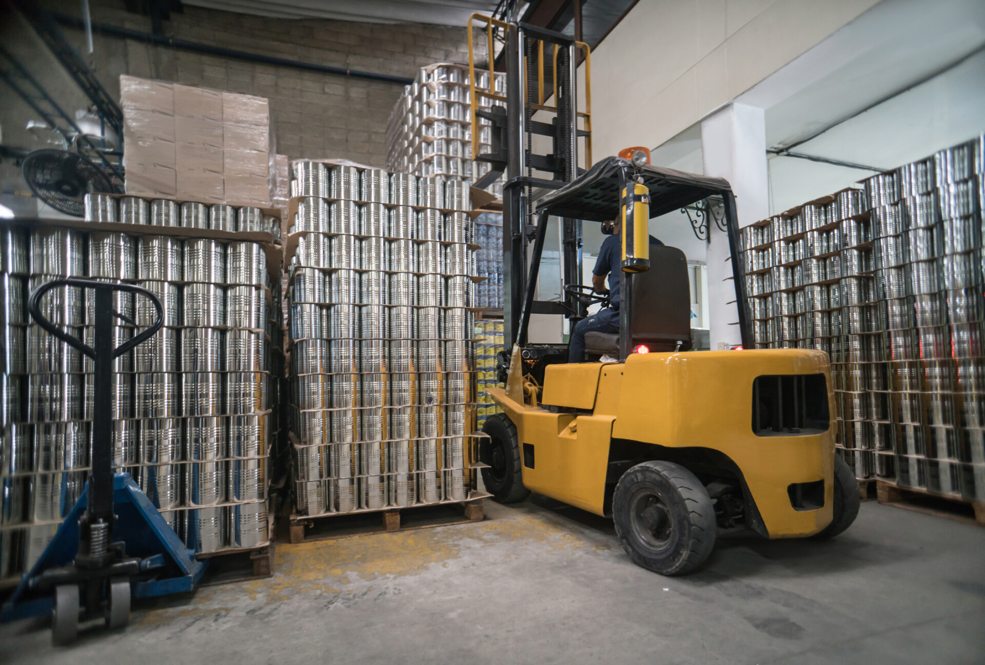 Man working at a metal factory moving things on a forklift